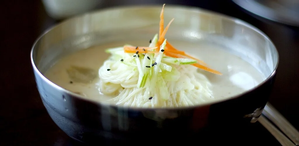 Bowl of creamy kongguksu with cucumber garnish